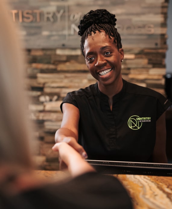 A photo of smiling team member greetings a client