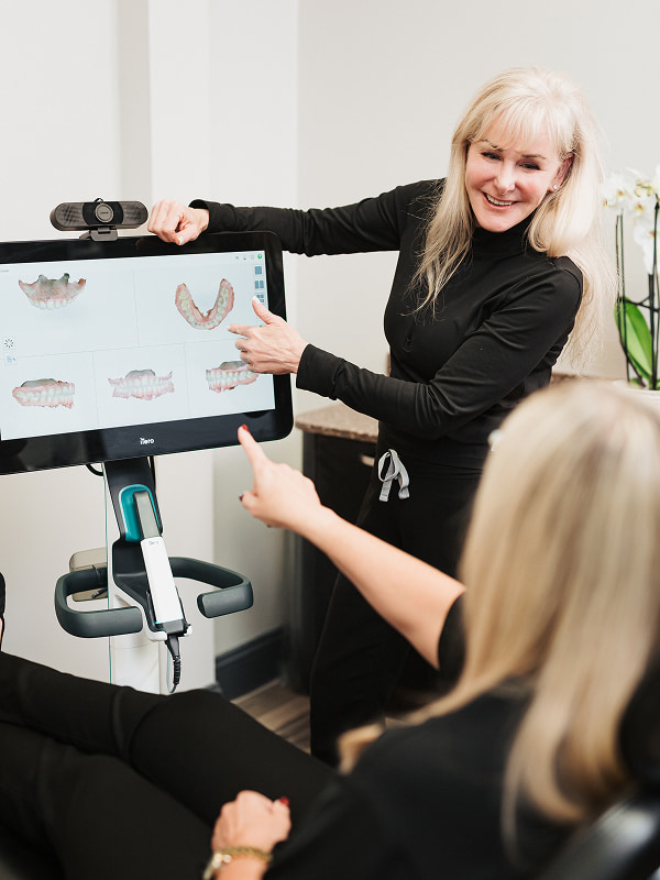 A team member of Dentistry of Norcross pointing at a screen