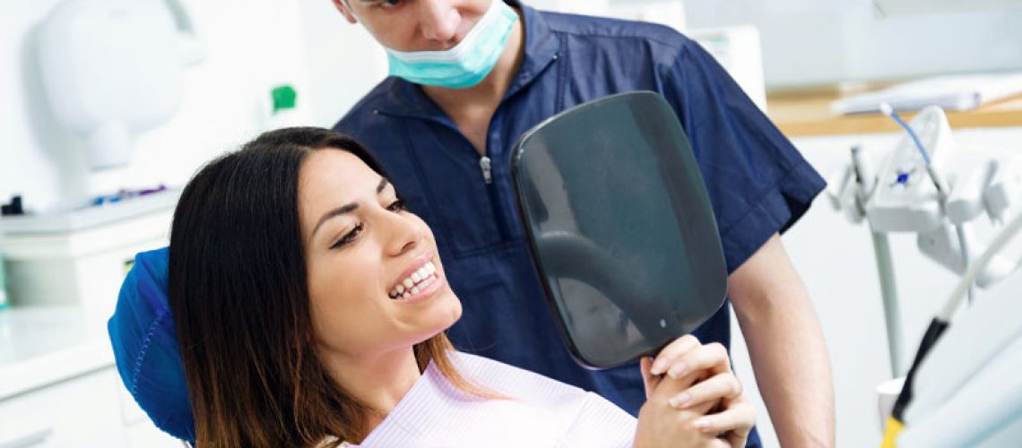 a dental implant surgery patient smiling after successfully getting dental implants