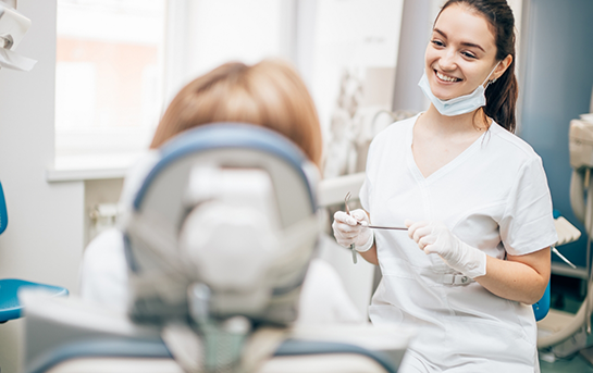 Dental team member smiling at a patient in the treatment chair