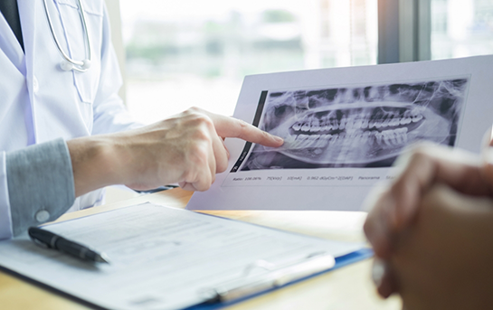 Dentist showing a patient an x ray of their teeth