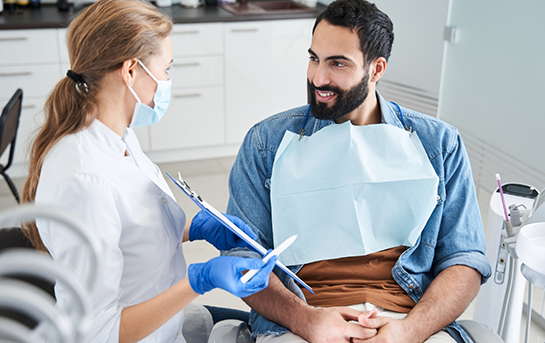 Man in the dental chair listening to his dentist