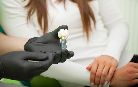 Dentist showing a dental implant to a patient