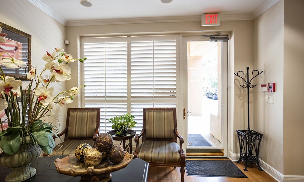 Dental treatment room with hedges visible through the window