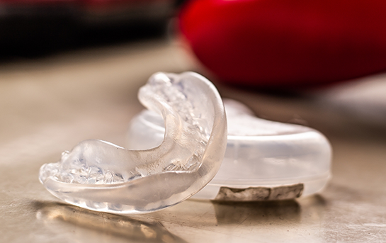 Clear nightguard next to its clear storage case