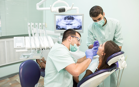 Dentist and assistant performing a dental procedure on a patient