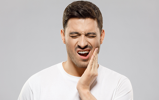 Man holding the side of his jaw in pain